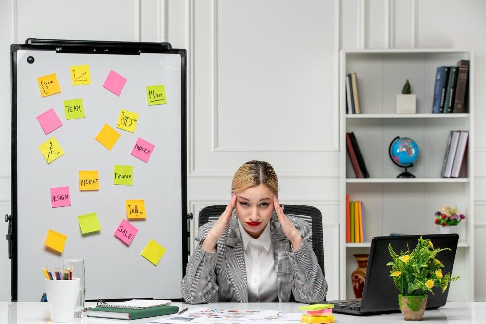 Profesional abrumada frente a post-its y tareas acumuladas, representando procesos ineficientes y falta de foco