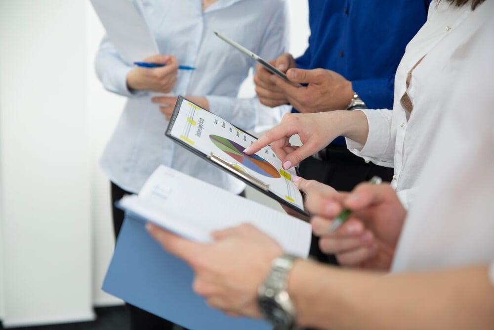 Profesionales revisando manuales de cumplimiento y estándares ISO en un entorno técnico