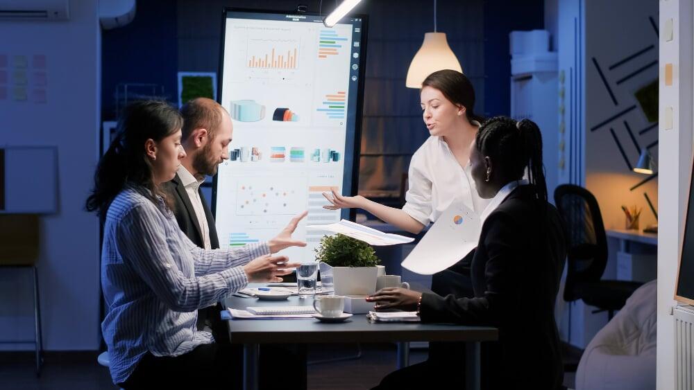 Grupo analizando datos en pantalla digital durante una sesión de transformación empresarial
